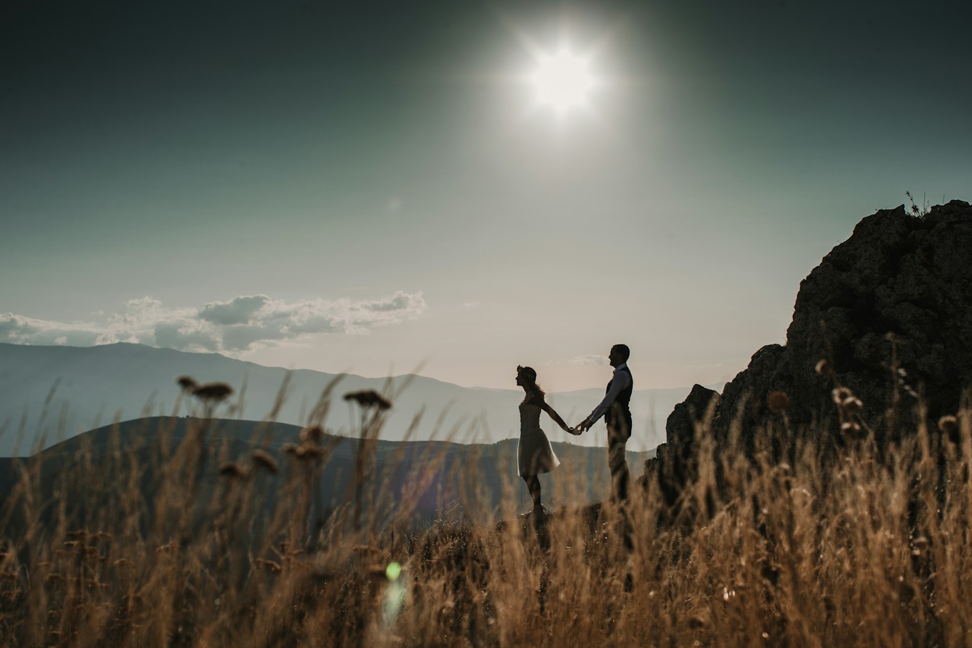 Wedding couple holding hands in a mountain landscape